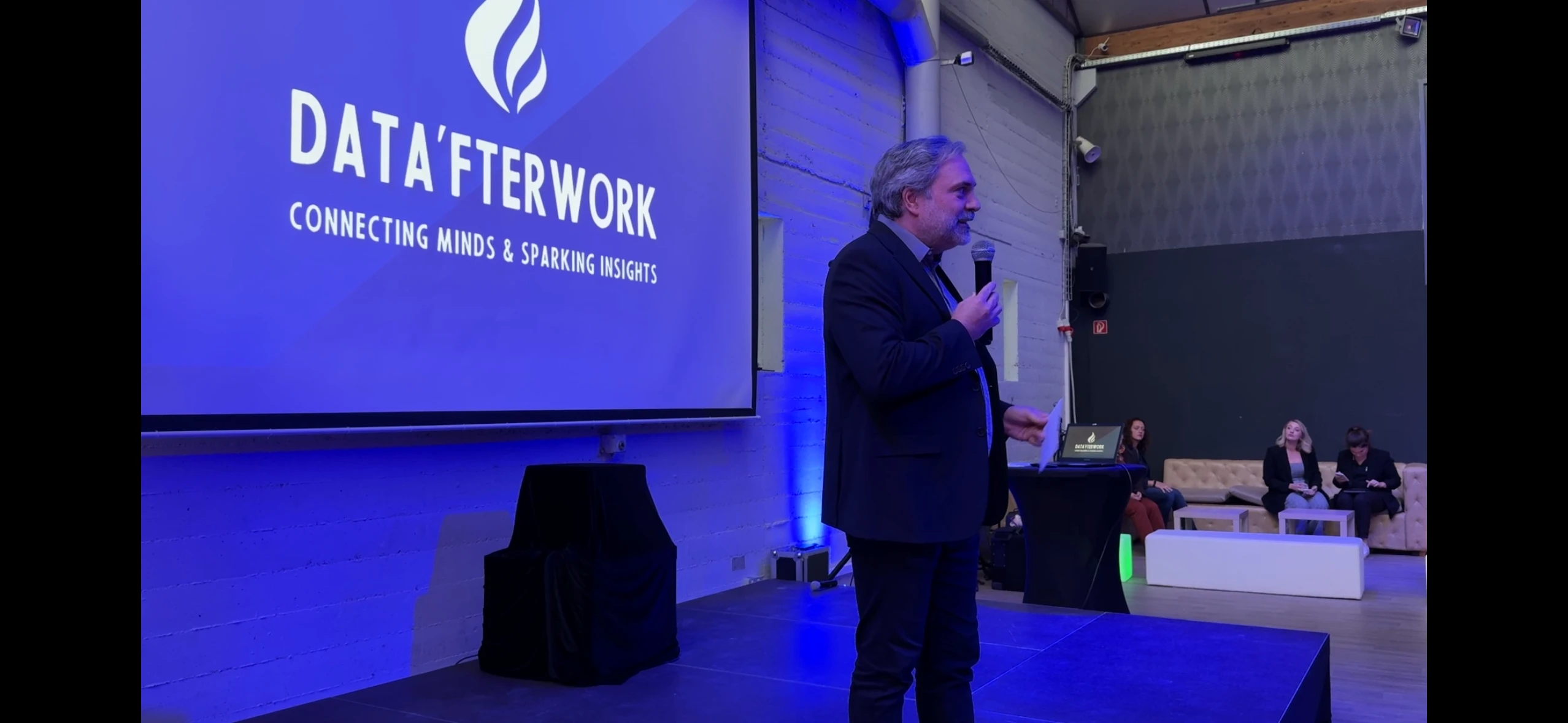 A Data'Talk speaker presenting on stage at a DatAfterwork evening
